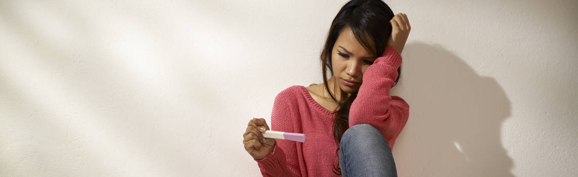Young Woman Contemplating a Pregnancy Test